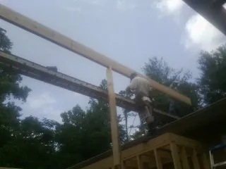 Carpenter setting a ridge beam over a new addition frame — Ice Dam Removal by Roofing Brothers in Stone Harbor