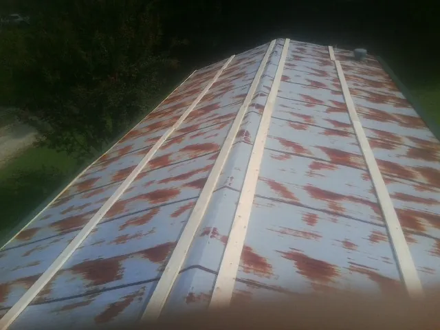 Rusted metal roof panels with new wood purlins before replacement — Storm Damage Roof Repair in Stone Harbor by Roofing Brothers