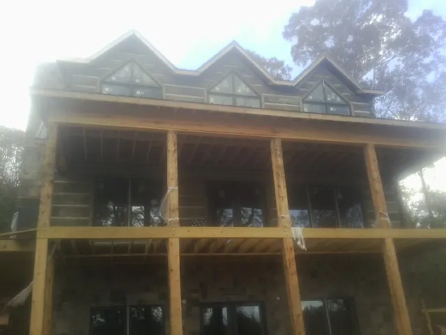 Dormers and porch framing on a large log home under construction — Roof Coating work by our crew in Stone Harbor