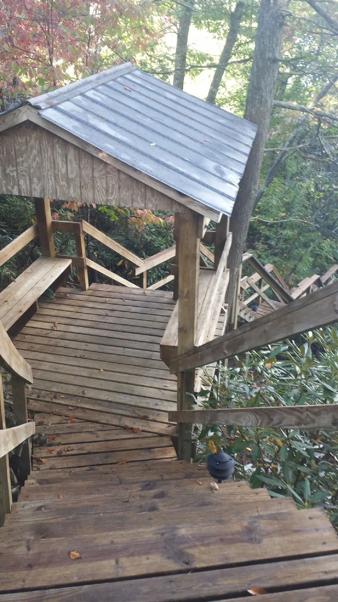 Metal roofed shelter over wooden steps on a wooded walkway — Skylight Repair & Installation work by our crew in Stone Harbor